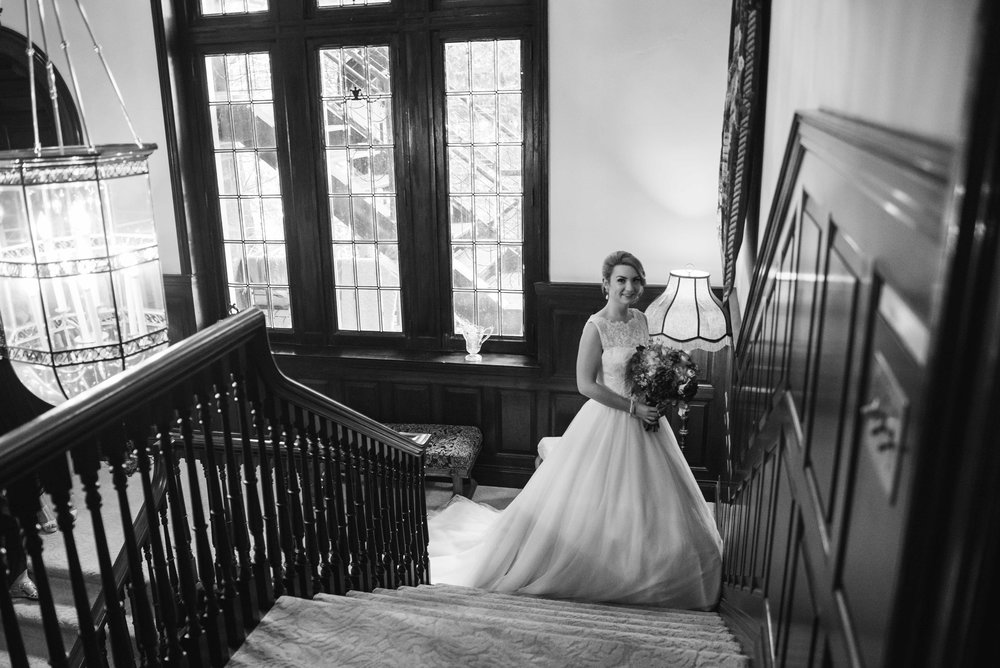 staircase at the gassaway mansion. The bride is posing in front of a grand staircase in black & white.