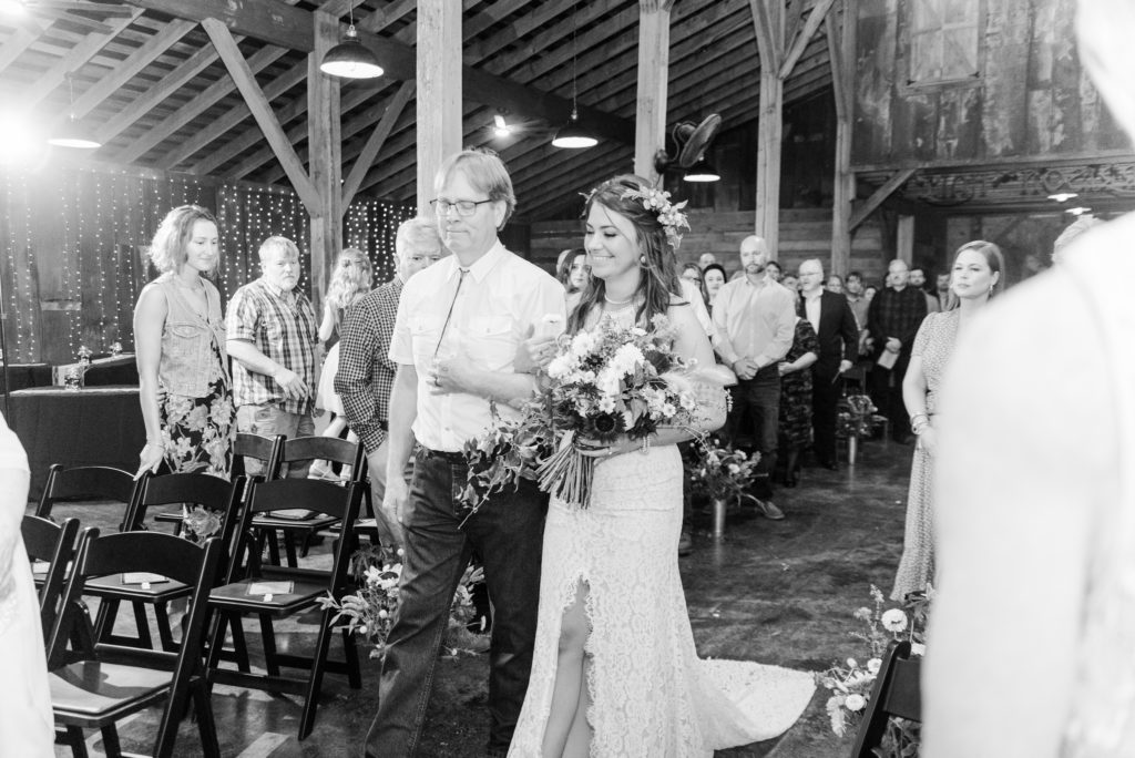 Iron Oak Barn Wedding in Pendleton SC - A bride and her father walk down the aisle in a rustic barn