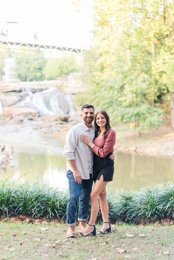 A couple in front of the Reedy River Falls at Falls Park in Greenville, SC