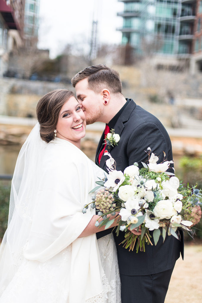 A bride in Groom share a kiss in Downtown Greenville, SC 