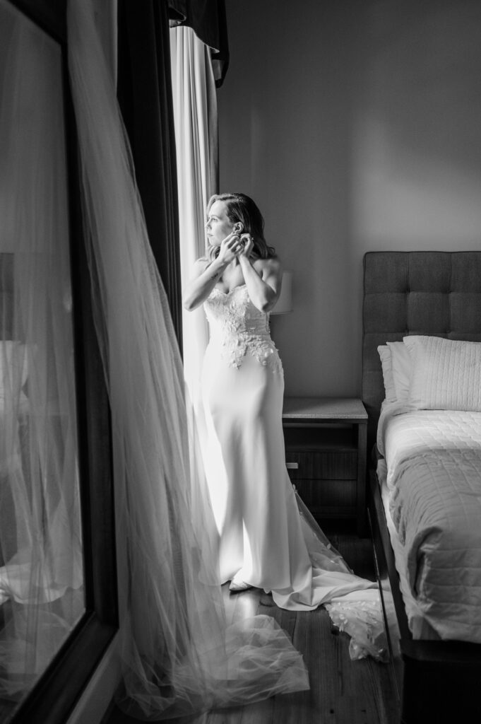 A bride puts on her earrings in Bride's Suite at The Bleckley Inn Anderson, SC