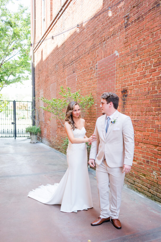 A couple sharing their first look in the alley courtyard of The Bleckley Inn