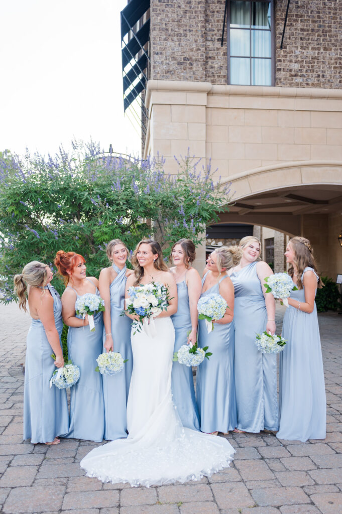 bridesmaids wearing blue dresses and smiling at the bride at the bleckley inn in anderson sc