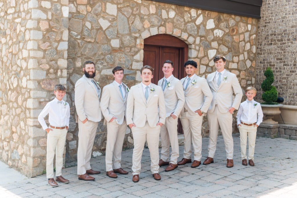 groomsmen standing in front of a stone wall at the bleckley inn