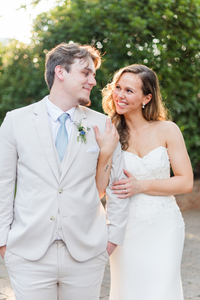 A bride and groom smile at each other lit by gorgeous sunlight at the bleckley inn